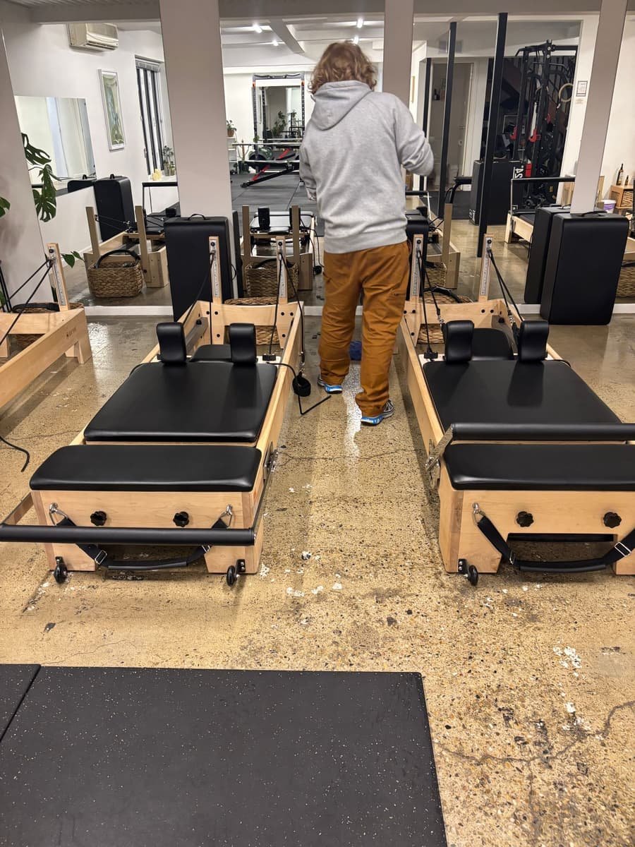 Pilates reformer studio after clean — equipment and floors spotless